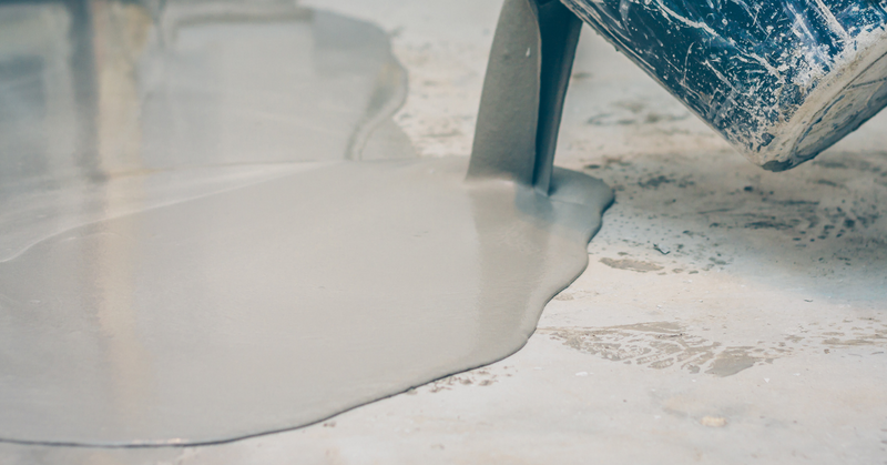 A layer of epoxy being poured onto an unfinished floor