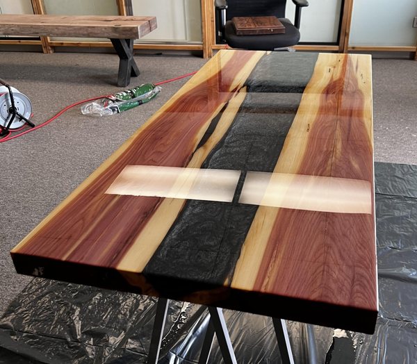 An epoxy river table made using UltraClear Deep Pour Epoxy and black powder pigment.