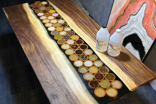 An epoxy river table filled with embedments of different spices, seeds, beans, etc.