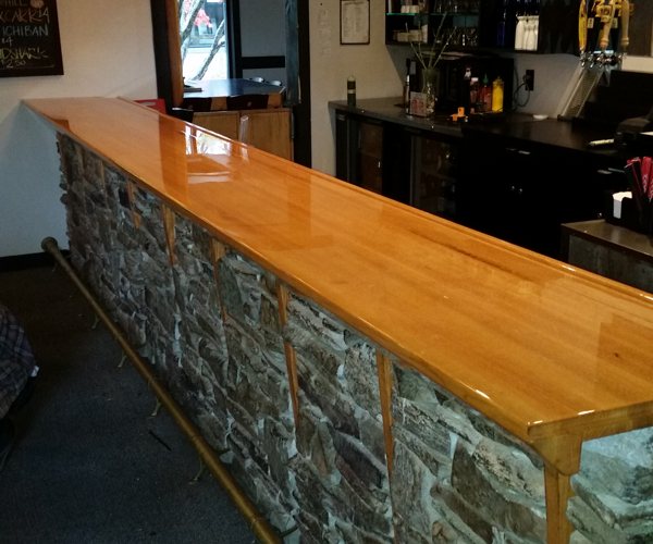 A long wooden epoxy bar top with an UltraClear Bar & Table Top Epoxy coating.
