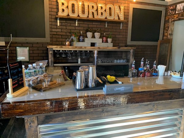 A commercial restaurant bar top with live edge wood rails and a bar top epoxy coating.