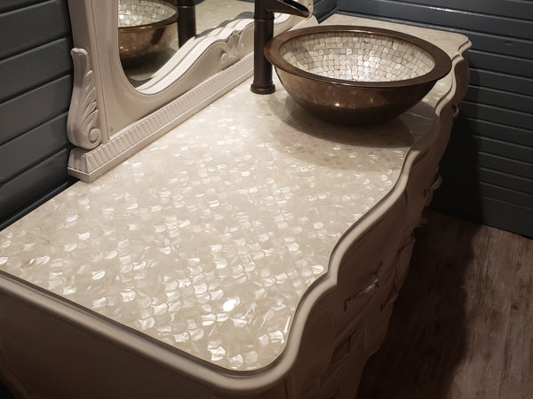 An epoxy bathroom countertop with a fishscale substrate texture and a vessel sink.